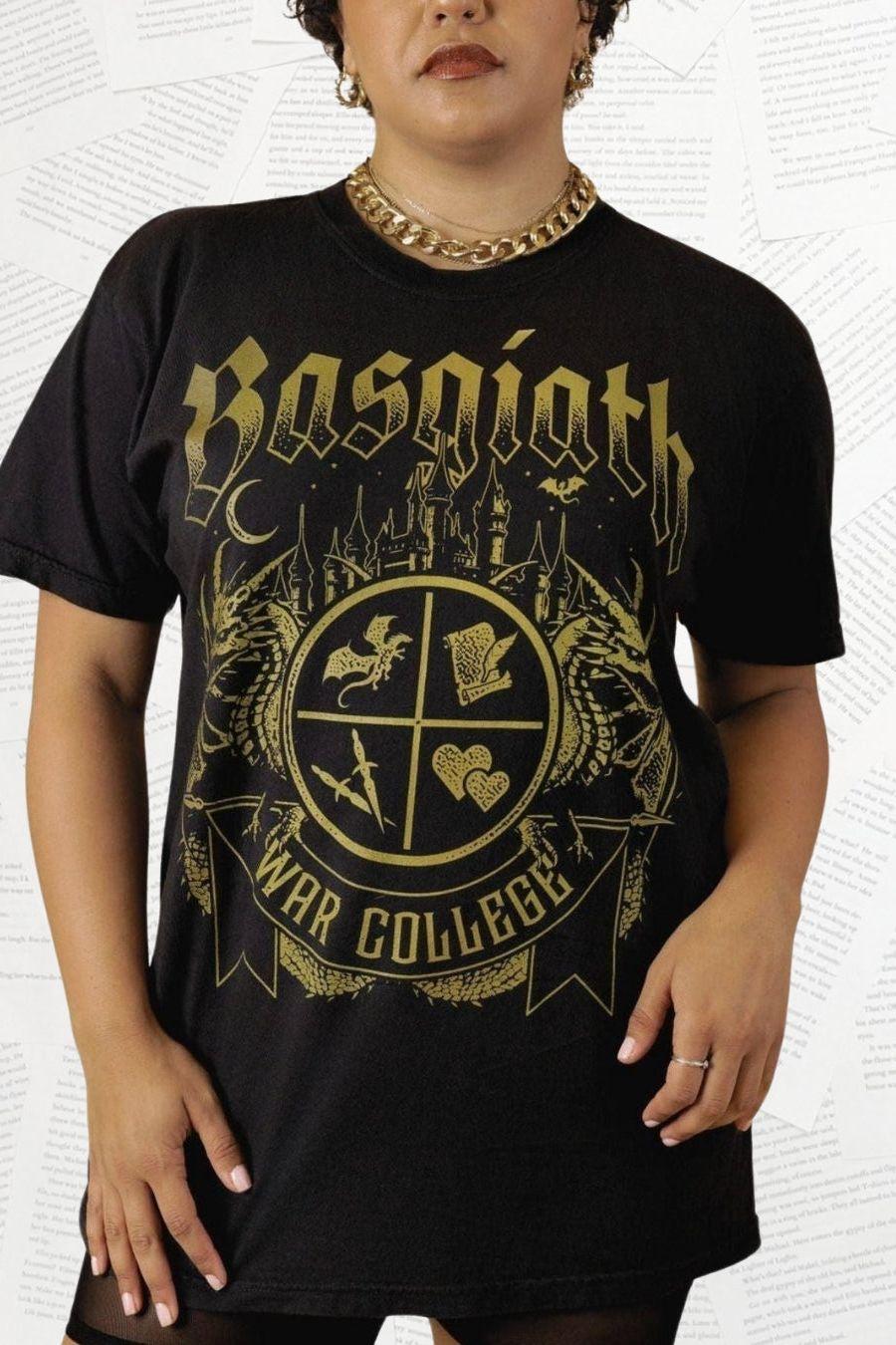 Woman wearing a black T-shirt featuring a Basgiath War College crest with fantasy symbols, dragons. Officially Licensed Fourth Wing Merch.