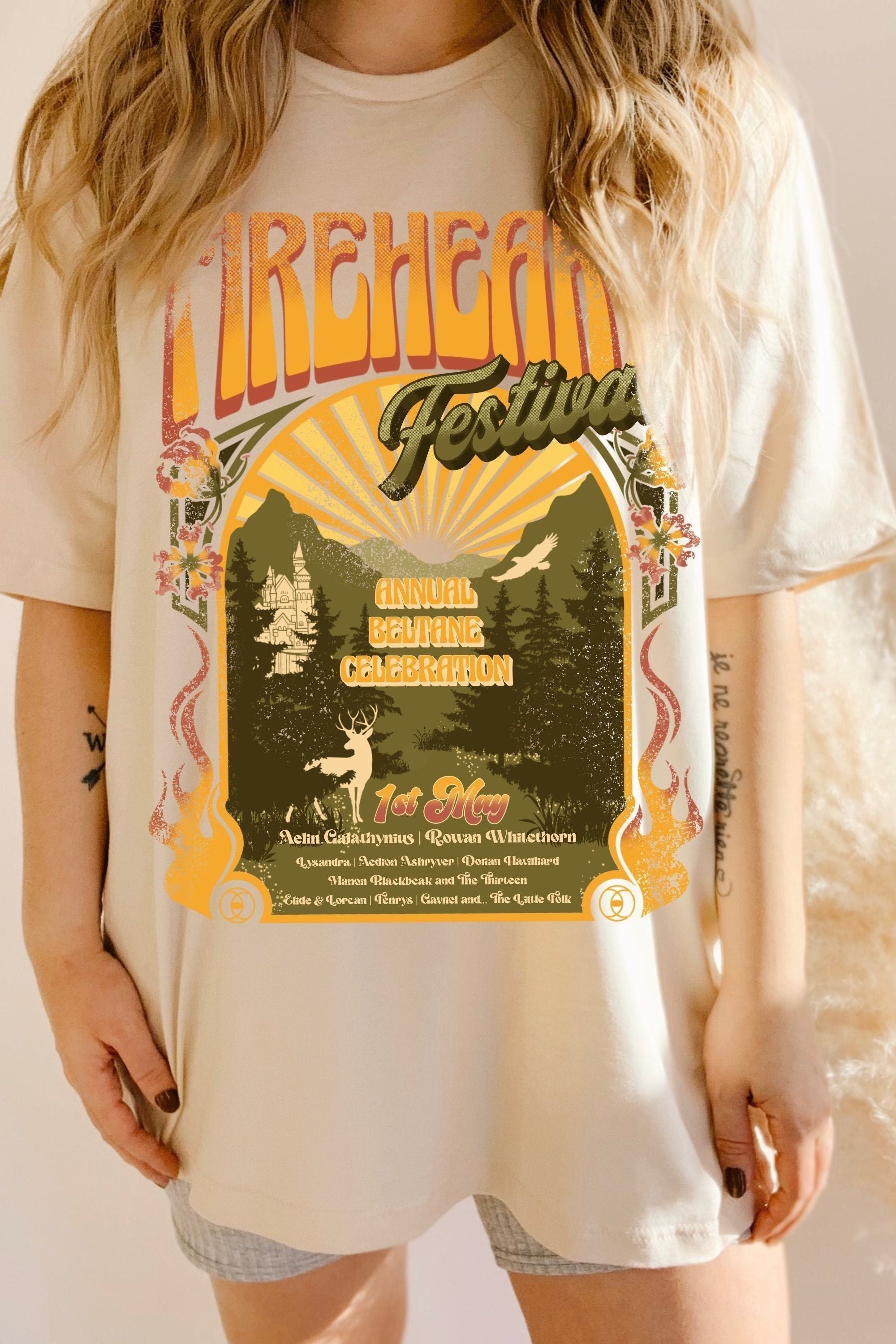 Model wearing a cream oversized t-shirt with a vintage festival-style print inspired by Throne of Glass by Sarah J. Maas, featuring Aelin Galathynius and Rowan Whitethorn.