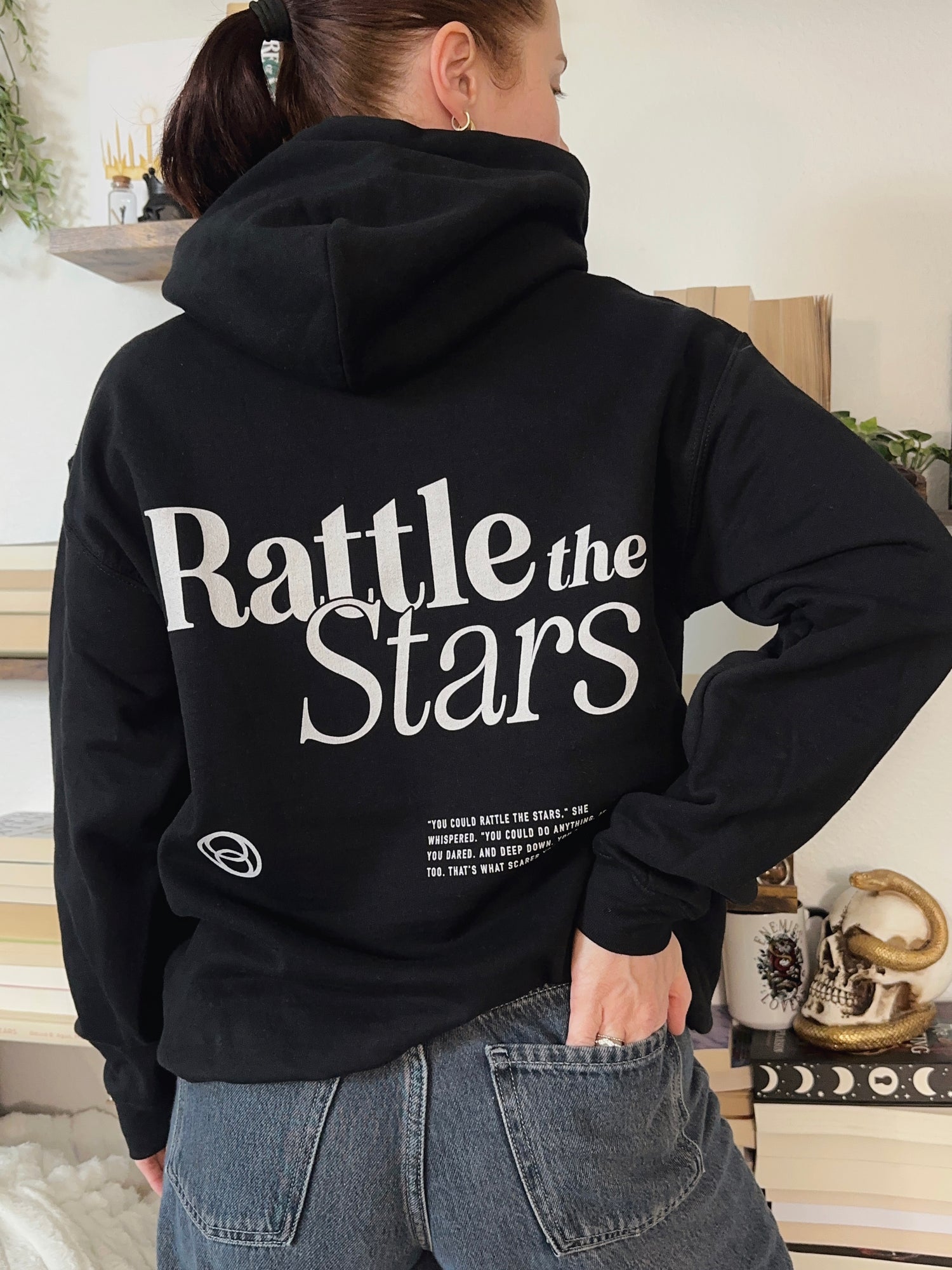 Black hoodie with large back print reading ‘Rattle the Stars’ in bold white font, inspired by the Throne of Glass quote by Sarah J Maas.