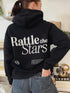 Black hoodie with large back print reading ‘Rattle the Stars’ in bold white font, inspired by the Throne of Glass quote by Sarah J Maas.