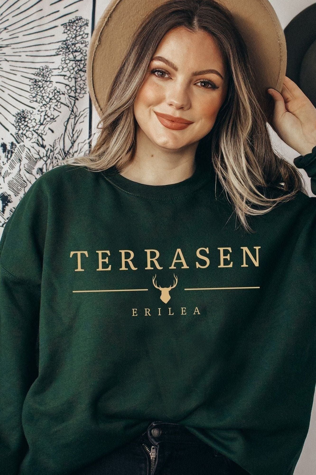 Dark green Terrasen sweatshirt with gold minimalist text and stag emblem, inspired by Sarah J Maas’s Throne of Glass kingdom of Erilea