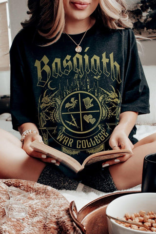 Woman wearing a black T-shirt featuring a Basgiath War College crest with fantasy symbols, dragons. Officially Licensed Fourth Wing Merch.
