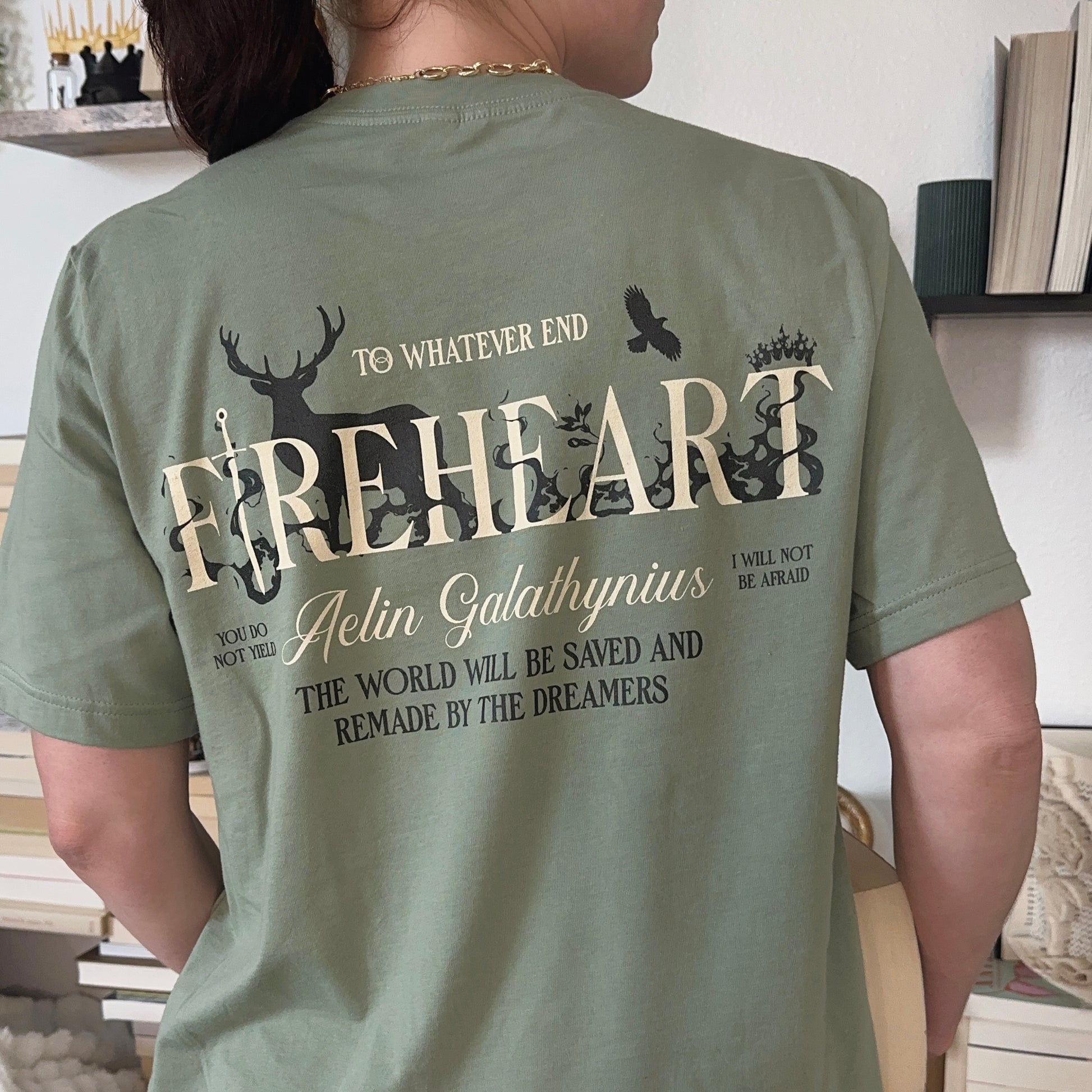 Back view of a sage green t-shirt printed with FIREHEART, a stag, a crown and an Aelin Galathynius quote, inspired by Throne of Glass by Sarah J. Maas