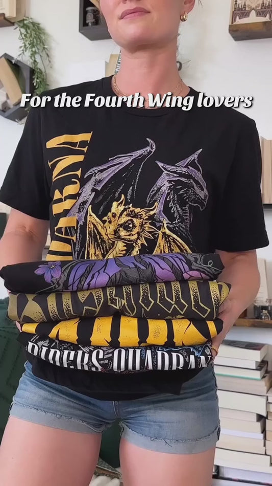 Try-on video: the black Violence t-shirt — the stained-glass arch in purple and lilac with the dark winged dragon, the golden hatchling at its base, 'Violence' above and 'I will not die today' along the plinth [focal 50 35]