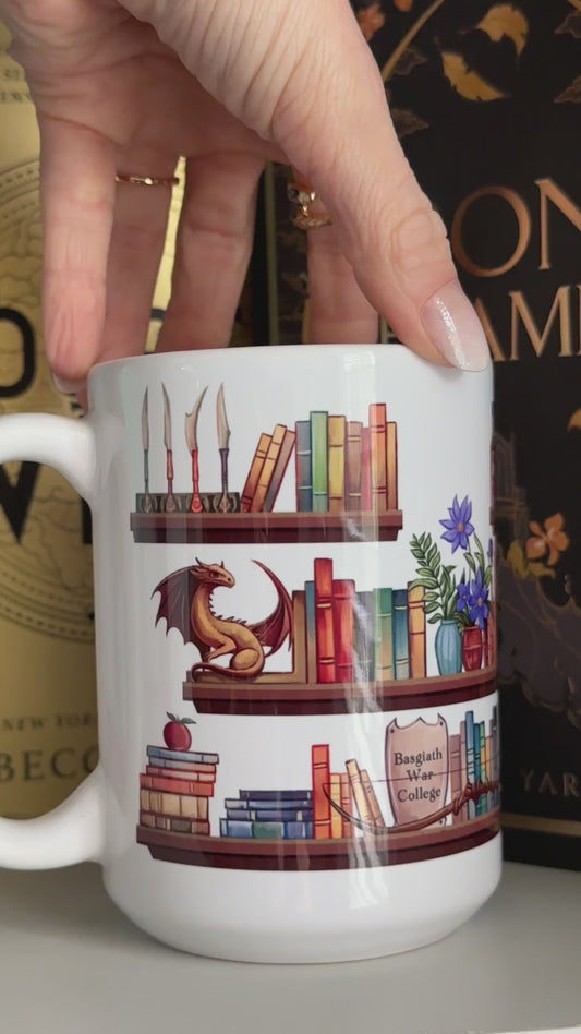 Product video: the Fourth Wing Shelfie mug turned by hand — the painted bookshelf wraps right round, shelves of books with the dragon figurine, the plant and the framed quote panel [focal 50 60]