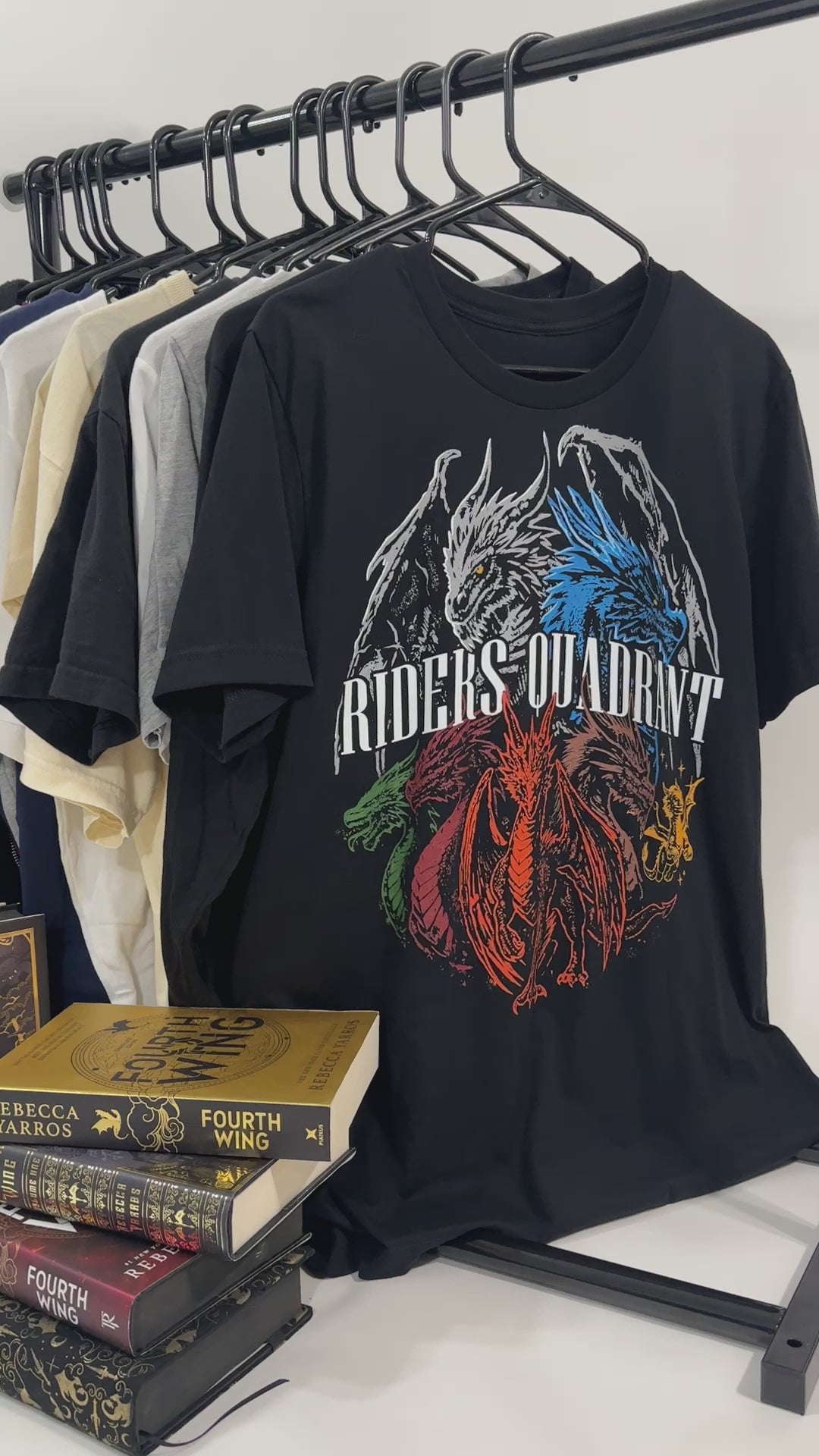 Product video: the black Riders Quadrant t-shirt back print — the four dragons in a ring, white, blue, green and red, around the RIDERS QUADRANT lettering [focal 50 40]