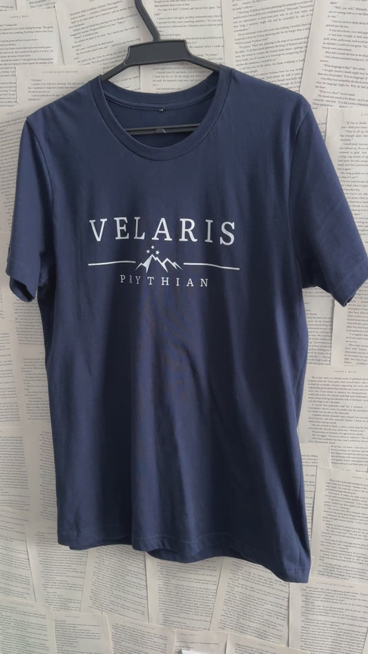Product video: the navy Velaris t-shirt on a hanger — the white VELARIS wordmark above the starred mountain line and PRYTHIAN beneath [focal 50 20]