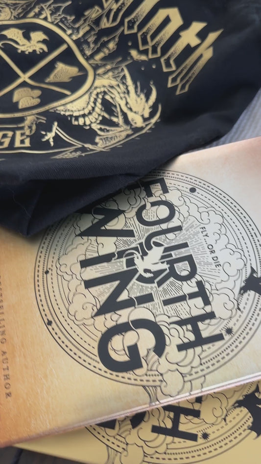 Product video: the black Basgiath War College tote with the Fourth Wing and Iron Flame hardbacks — the gold gothic Basgiath lettering above the War College crest and banner [focal 50 50]