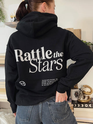 Black hoodie with large back print reading ‘Rattle the Stars’ in bold white font, inspired by the Throne of Glass quote by Sarah J Maas.