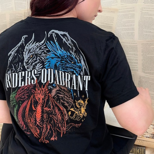Back of the black Riders Quadrant t-shirt worn while reading, white, blue, red, green and gold dragons around RIDERS QUADRANT lettering, Fourth Wing merch inspired by Rebecca Yarros