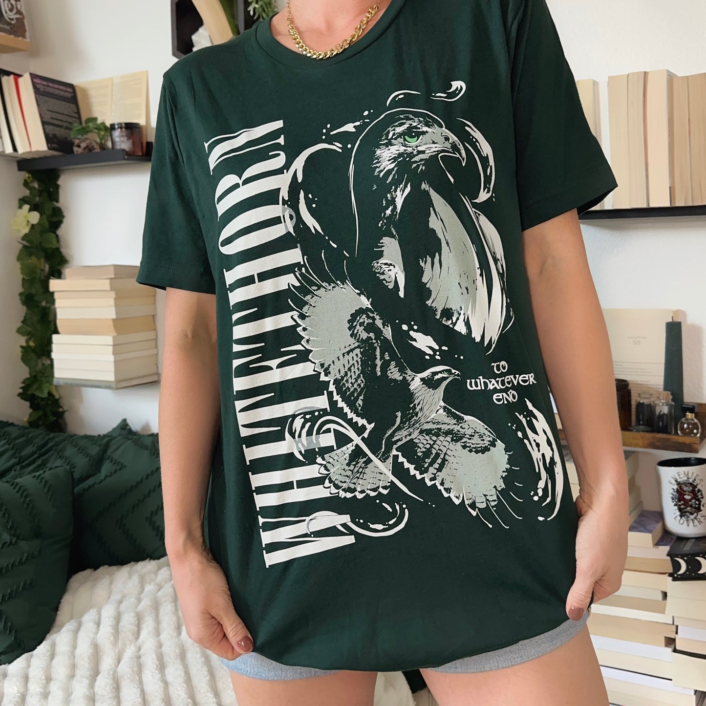 Model wearing a dark green t-shirt with a large white hawk, a second hawk in flight and WHITETHORN down one side, inspired by Throne of Glass by Sarah J. Maas