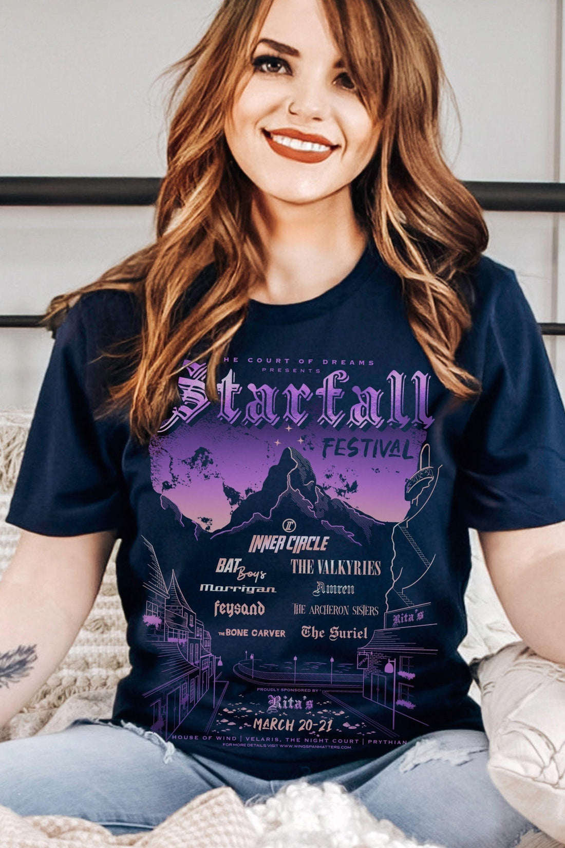 Woman wearing officially licensed Starfall festival T-Shirt inspired by ACOTAR night court, with Velaris and Inner Circle references in a band-style design